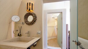 A bathroom with a large sink, a mirror, a striped wall decoration, and a door labeled "The Ranch".