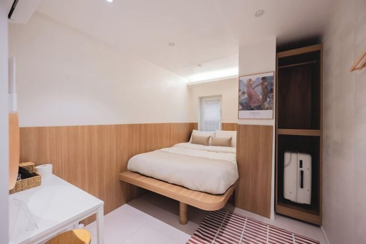 A bedroom with a bed, bedside table, and a wardrobe.