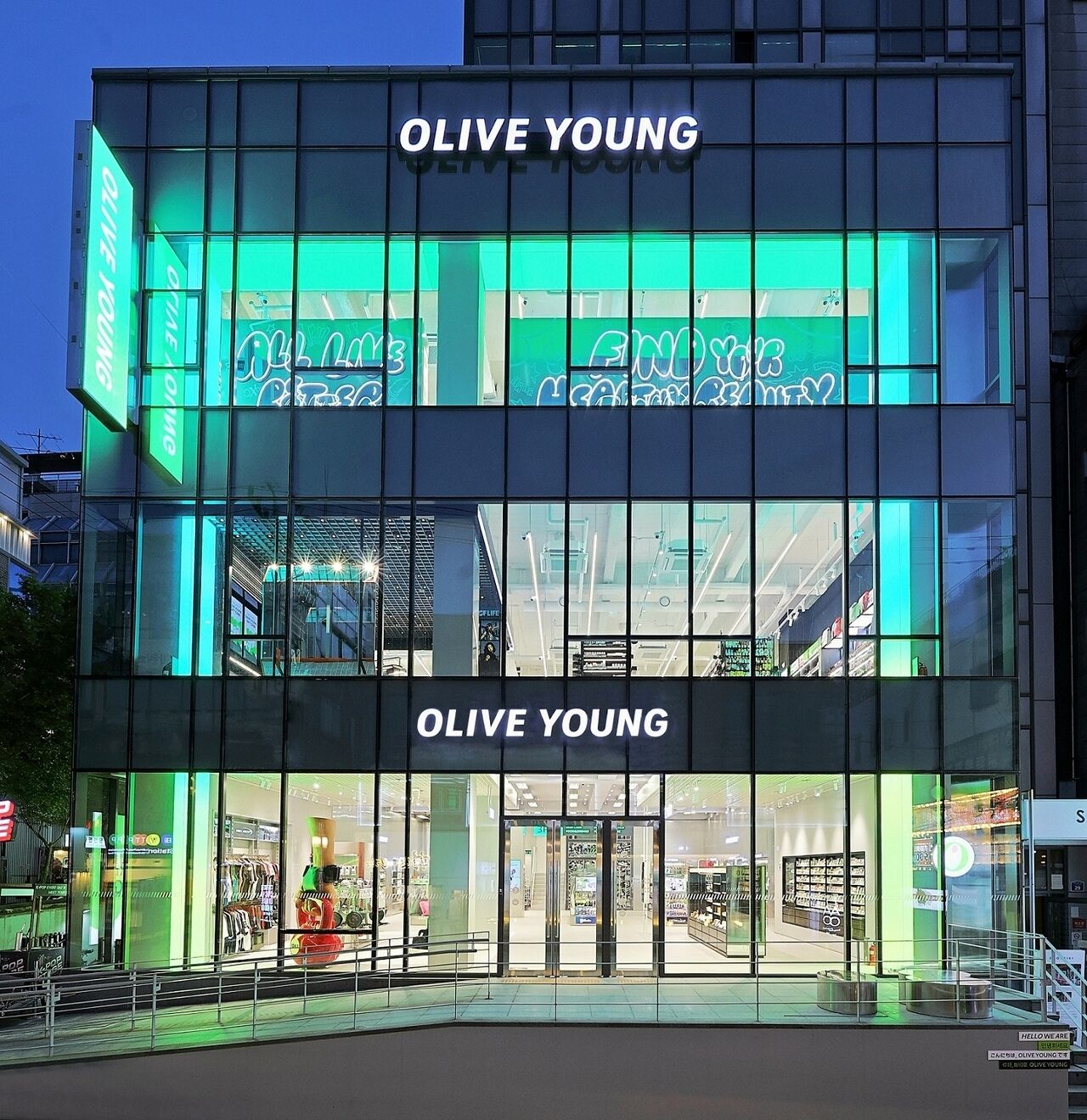 A modern building with 'OLIVE YOUNG' signage, large glass windows, and a visible entrance.