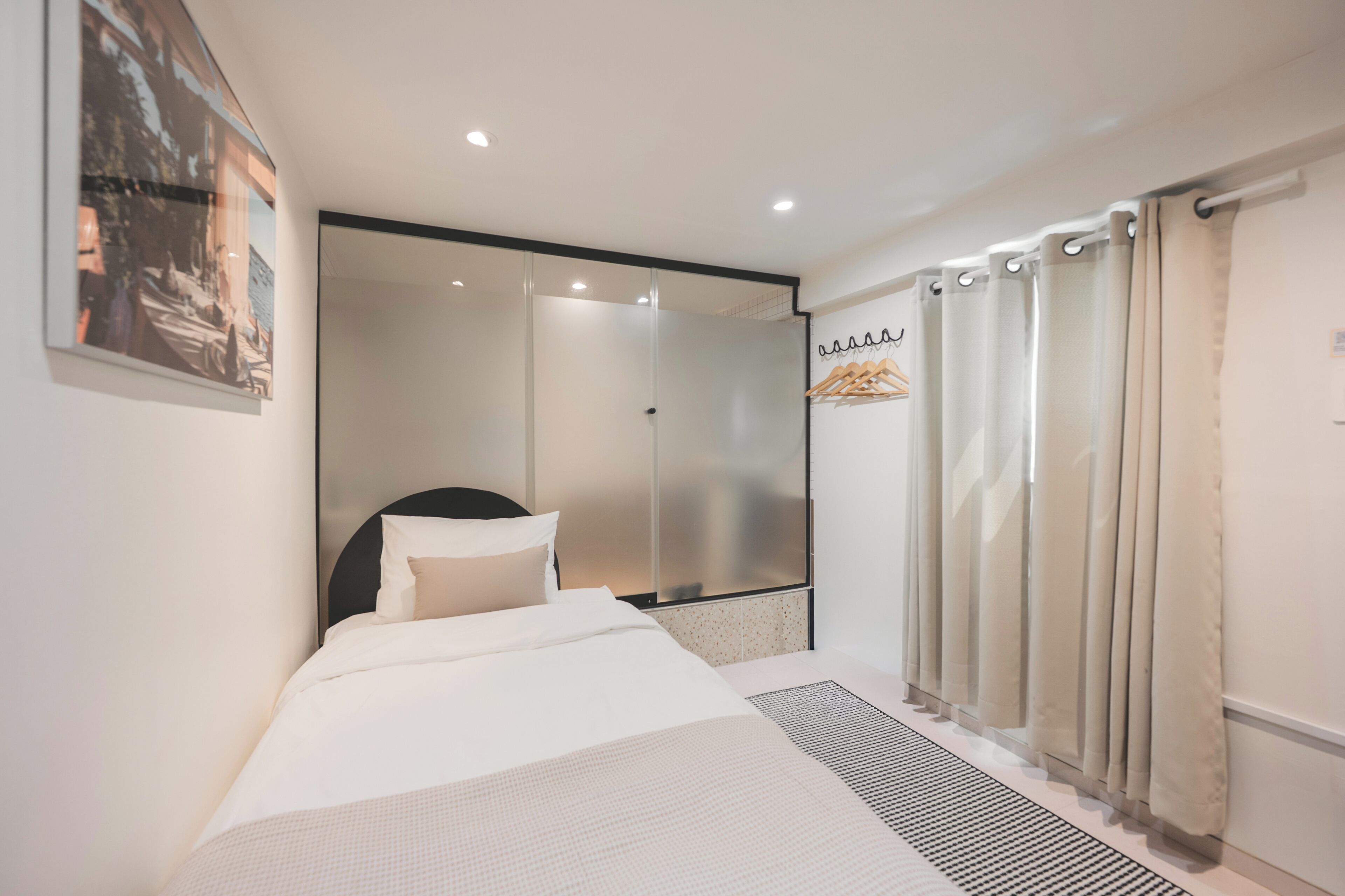 Een moderne hotelkamer met een bed, een douche en uitzicht op de omgeving.
