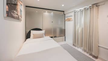 Een moderne hotelkamer met een bed, een douche en uitzicht op de omgeving.