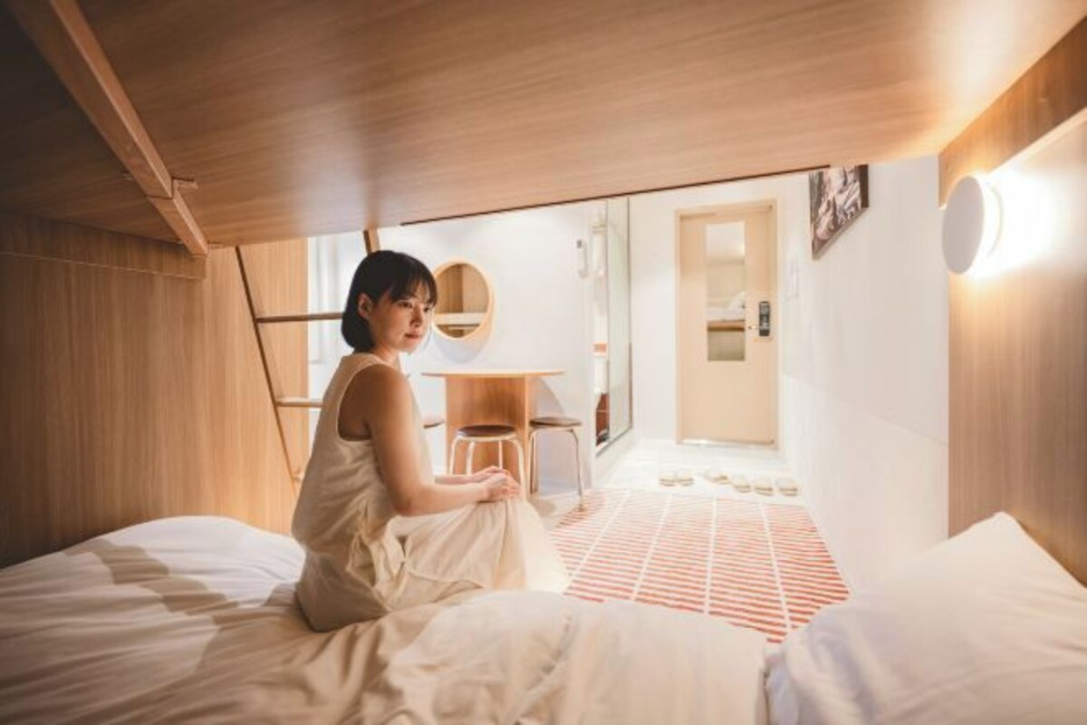Um quarto com uma cama, uma escrivaninha e uma cadeira.