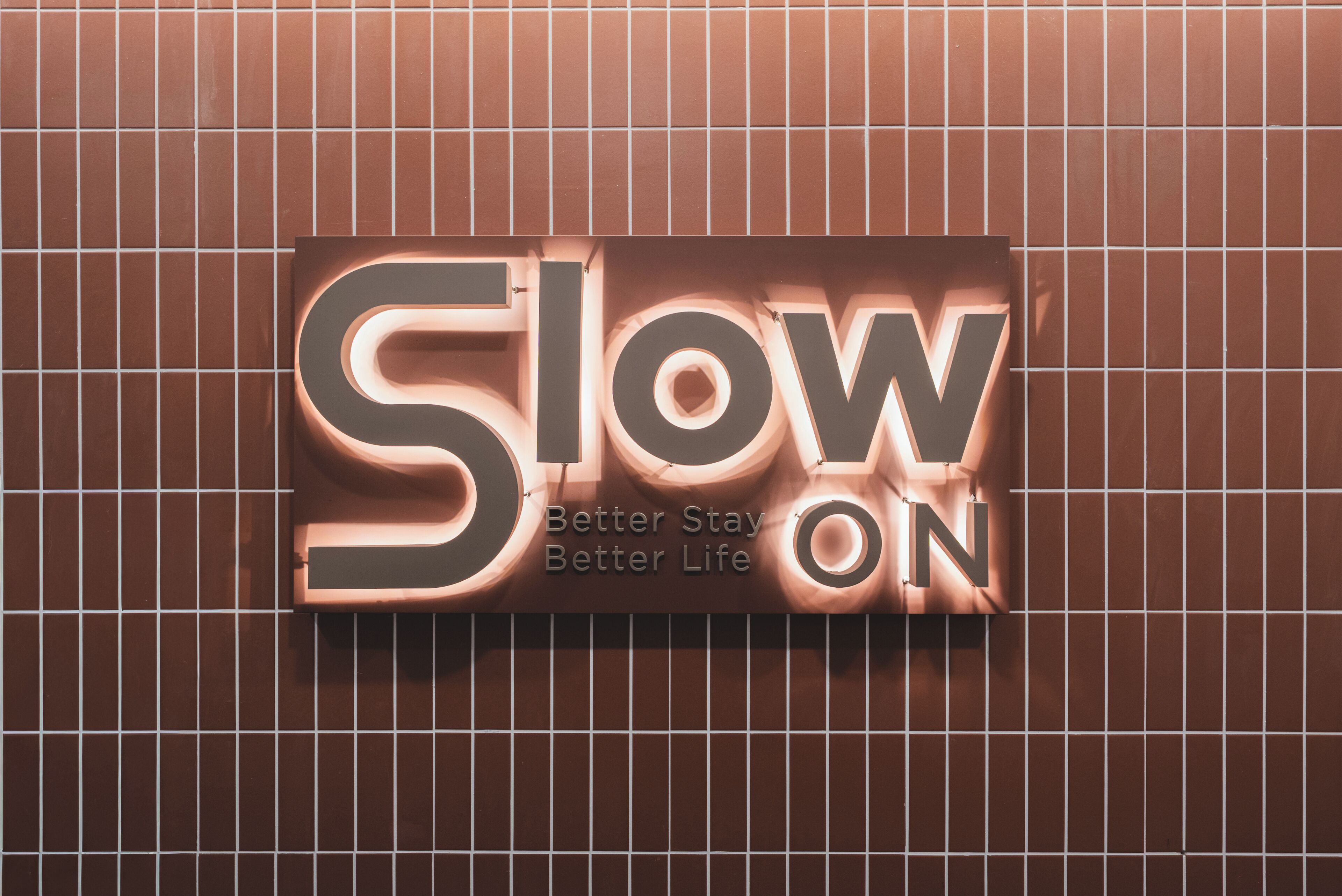 A wall with a sign that reads 'Slow ON' and 'Better Stay Better Life'.