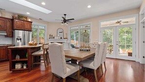 A spacious kitchen with a large island, wooden cabinets, and a dining area with a wooden table and chairs.