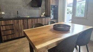 A modern kitchen with a wooden countertop, a built-in stove, and a black range hood.