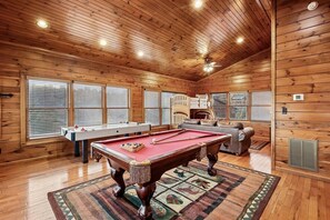 A wooden-paneled room with a pool table, a sofa, and a ceiling fan. - Scenic Resort Cabin w/ Game Area & Views (Gatlinburg)