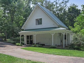 A white house with a green roof, a porch, and a garage. - Seven Sisters On Little Glen (Empire)