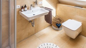 A bathroom with a white sink, a toilet, and a shower area. - Zum Brandenburger Tor 17 (Damme)