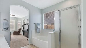 Une salle de bain moderne avec une baignoire, une douche à l’italienne et un meuble-lavabo.