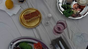 A table set with plates of food, glasses, and cutlery.