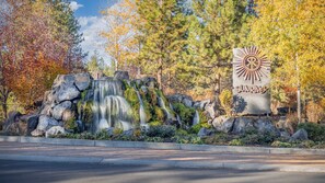 A waterfall with a sign labeled 'SUNRIVER' in a natural setting with trees and rocks. - Updated, modern, in Sunriver, great space, no pets (Sunriver)