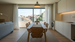 Een modern appartement met een eethoek, bank en keuken.