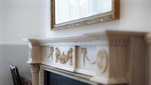 A fireplace with intricate carvings and a mirror above it. - Stunning Apartment | Lincoln City Centre | Parking (Lincoln)