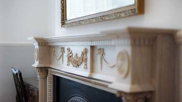 A fireplace with intricate carvings and a mirror above it.