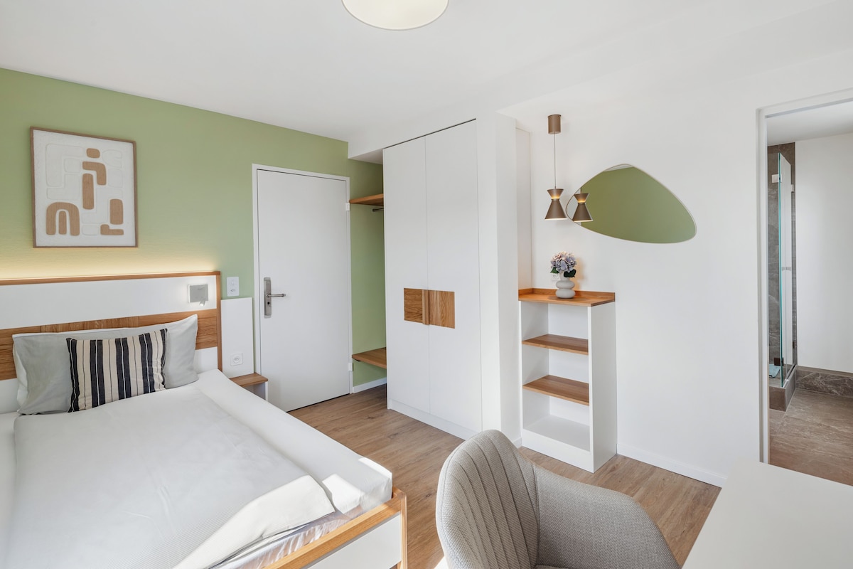 Une chambre d’hôtel moderne équipée d’un lit, d’une chaise, d’un bureau et d’une armoire.