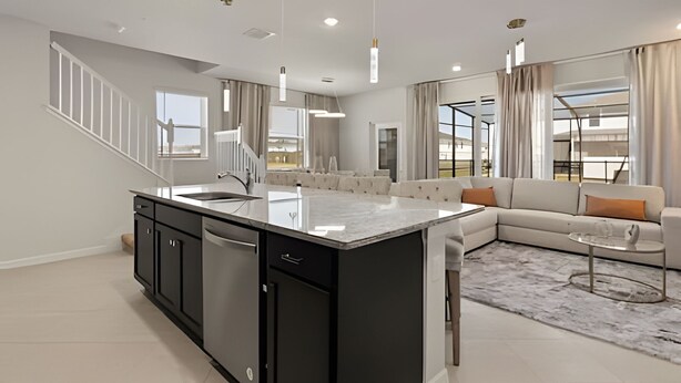 A modern kitchen with a central island, built-in appliances, and pendant lighting. - Luxurious 5BD Space at Windsor Cay Resort (Clermont)