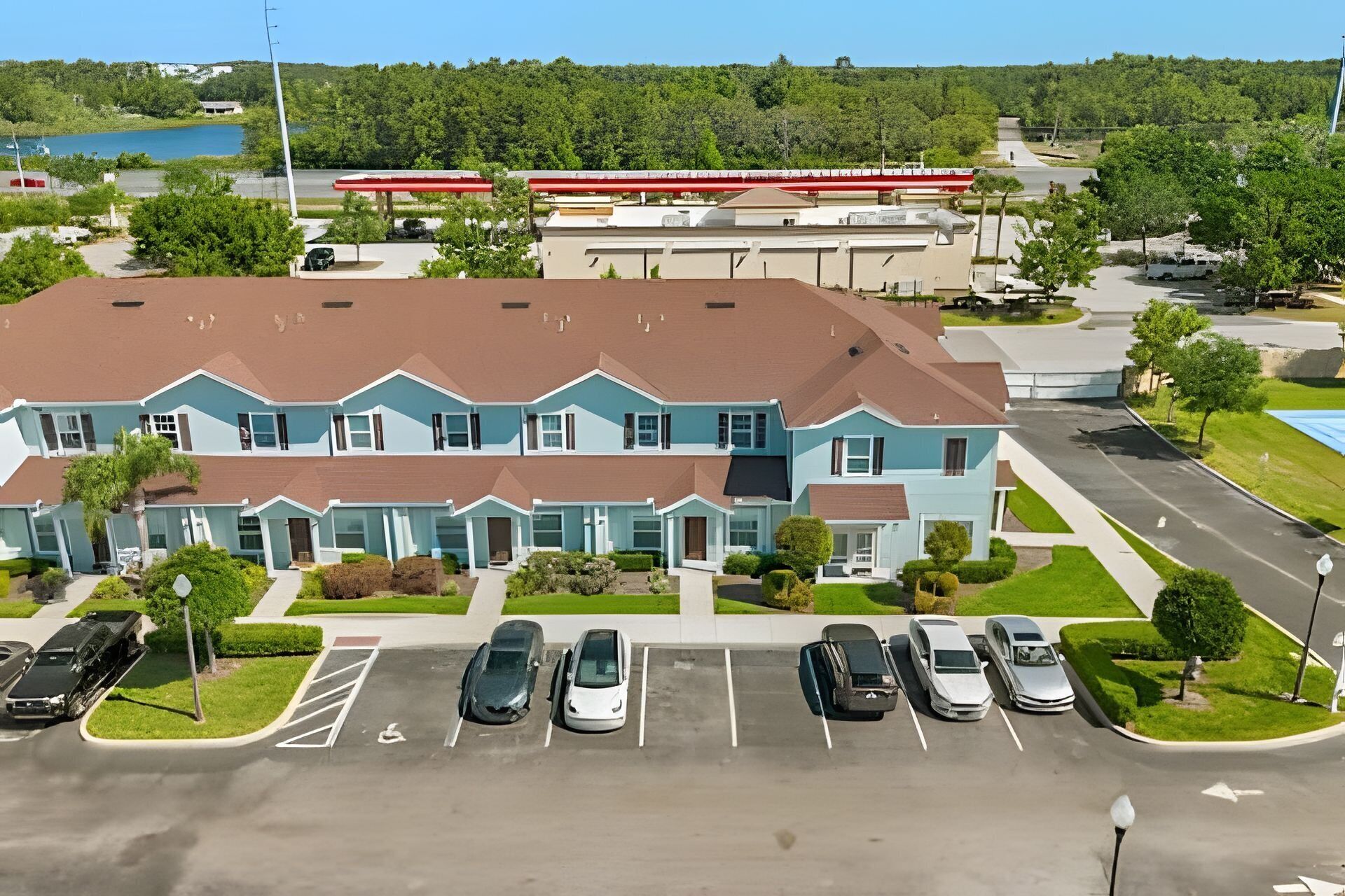 A multi-story building with a parking lot in front.