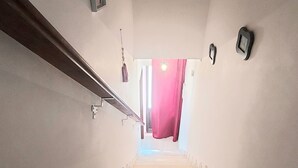 A staircase leading to a landing with a red curtain at the top. - Vacation home Casa Rose, affordable accommodation (4 pers), ideal for long-term vacation. (Luz)