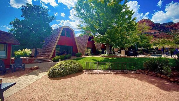 A building with a unique geometric design, a grassy area, and a playground. - Charming Chalet with Kitchen and Scenic Views.  (Sedona)
