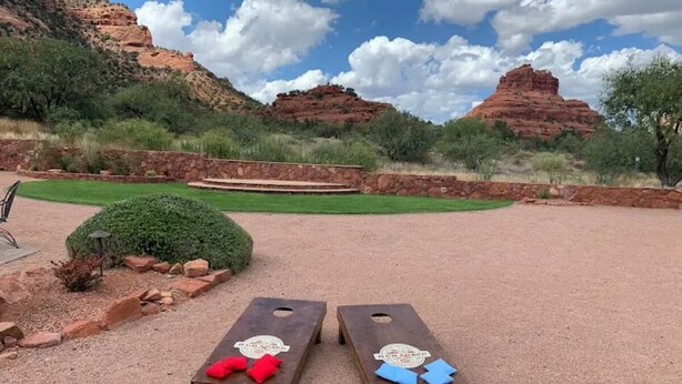 Two wooden bean bags with red and blue cushions in a desert landscape with red rock formations and a clear sky. - A stunning Pet-Friendly Studio facing the Red Rocks! (Sedona)