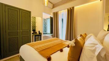 Une chambre d’hôtel avec un grand lit, une armoire, un bureau et une fenêtre avec des rideaux.