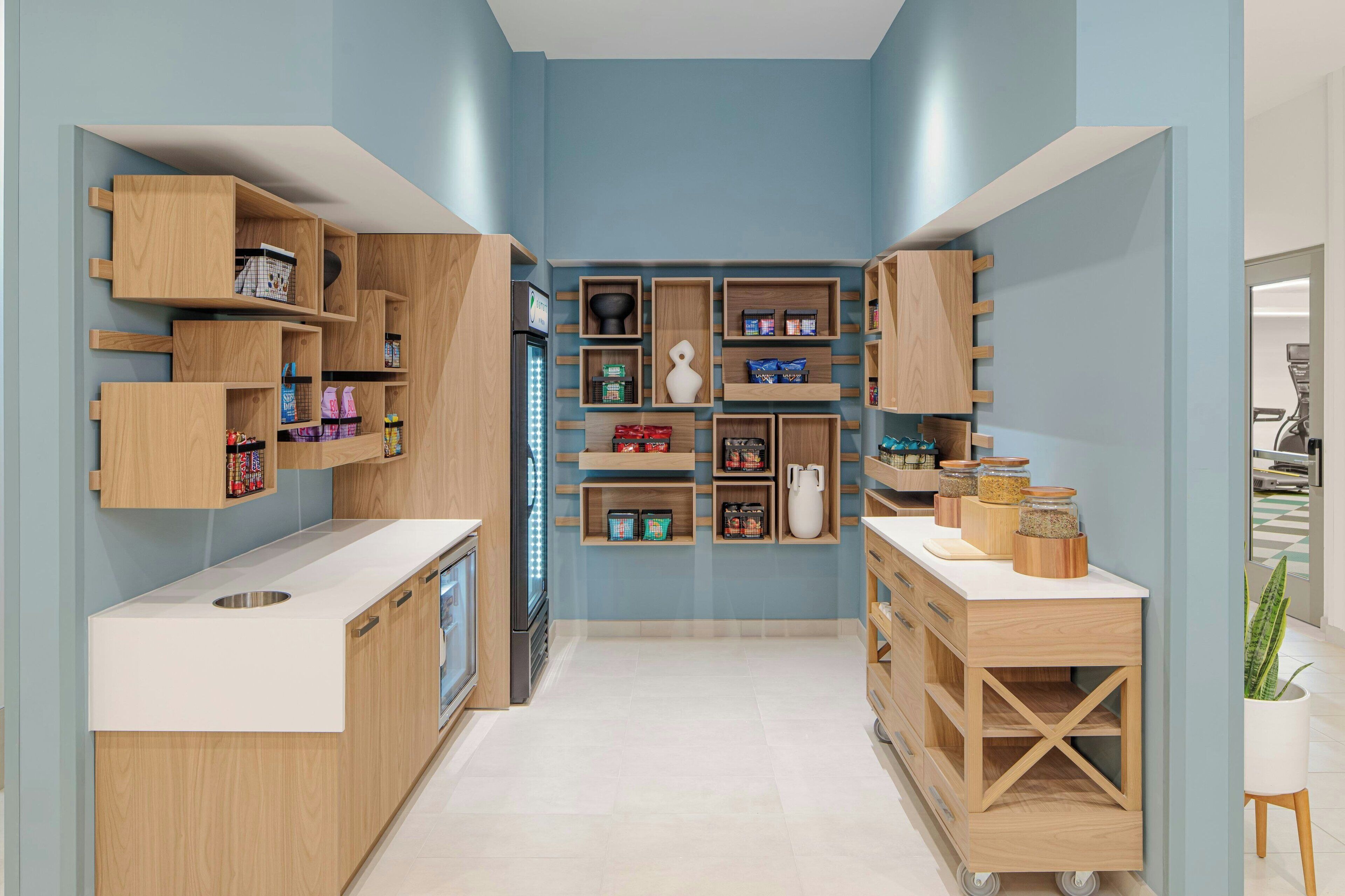 A modern kitchen with wooden cabinetry, a white countertop, and various kitchen appliances.