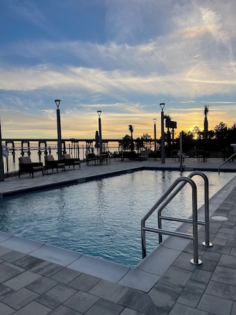 Una piscina al aire libre de temporada, sombrillas