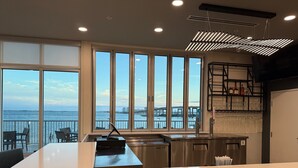 A modern kitchen with large windows, a bar area, and a view of the water.