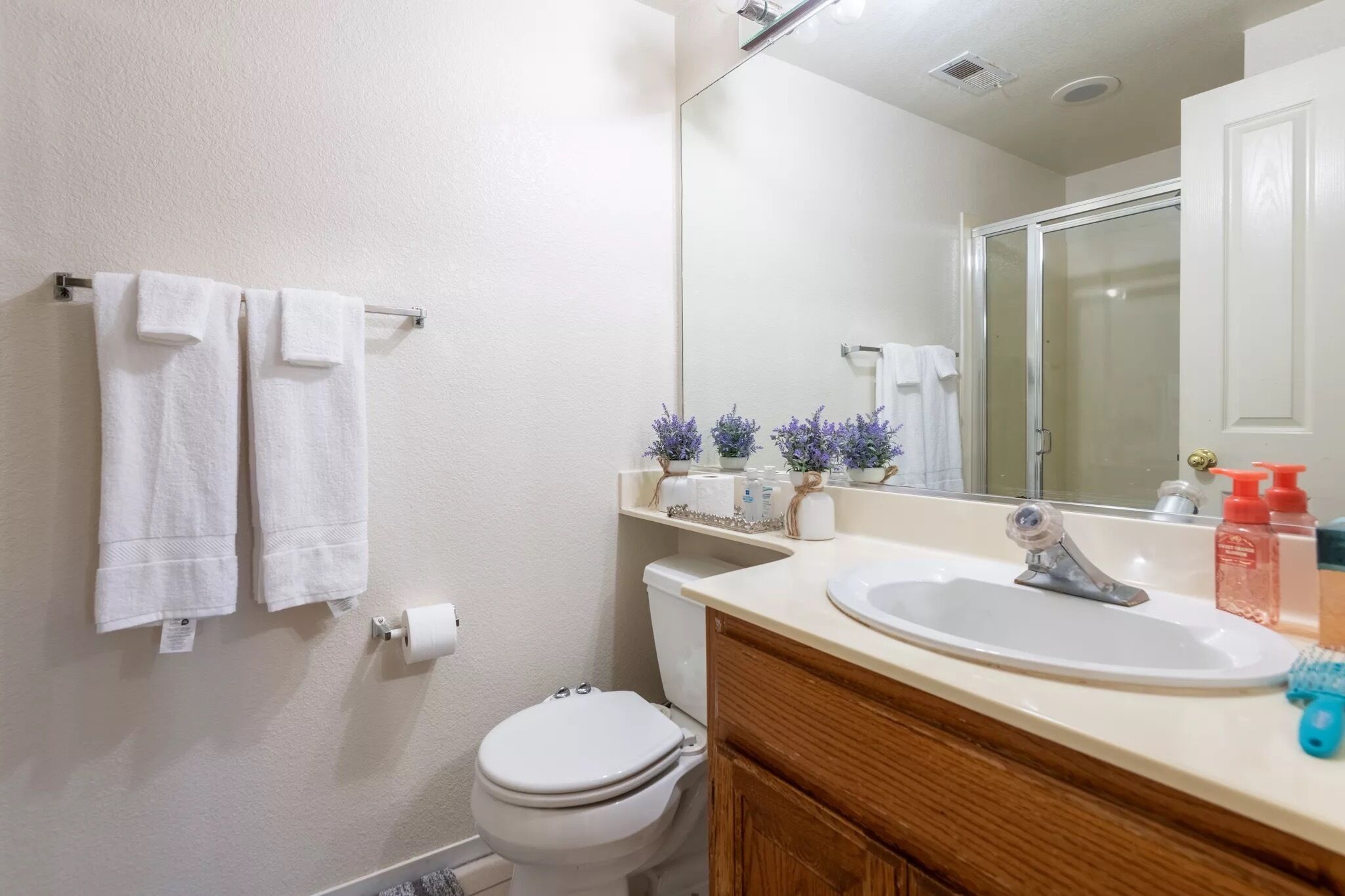 Ein Badezimmer mit Toilette, Waschbecken, Spiegel und Handtuchhalter.