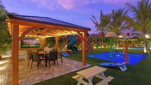 An outdoor play area with a slide, climbing wall, and picnic table. - Private Splash Pad, Pickleball, Htd. Pool, Hot Tub (Bradenton)