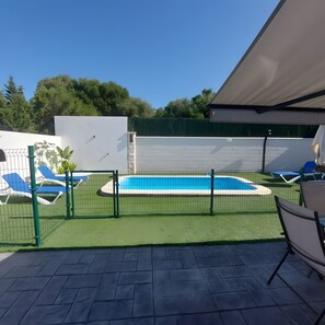 A swimming pool with a surrounding fence, a covered patio area, and a view of trees in the background. - Holiday Home 'Alex 1' with Private Pool, Wi-Fi and Air Conditioning (Zahora)