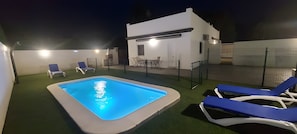 A swimming pool with lounge chairs, a small patio area, and a white building with a flat roof. - Holiday Home 'Alex 1' with Private Pool, Wi-Fi and Air Conditioning (Zahora)