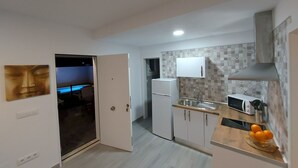 Une cuisine moderne avec des meubles blancs, un four à micro-ondes et un évier.