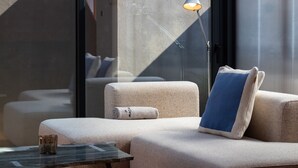 A modern lounge area with a sofa, a small table, and a floor lamp.