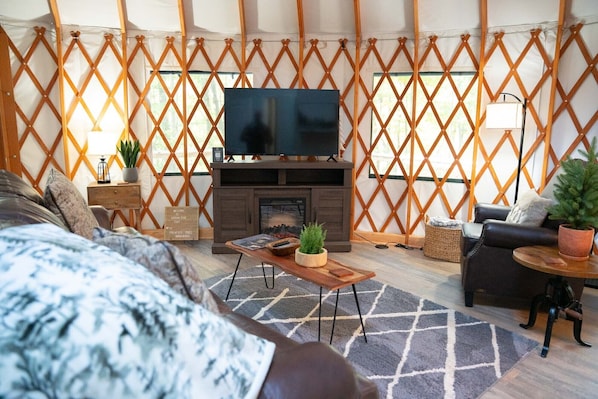 Ein gemütliches Wohnzimmer mit Kamin, Fernseher und einer bequemen Sitzecke.