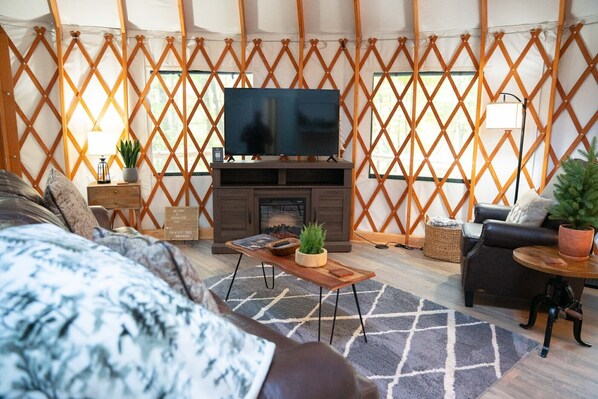 Un espacio de sala acogedor con chimenea, televisor de pantalla plana y asientos cómodos.