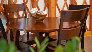 Une table ronde en bois sur laquelle repose un panier tressé contenant divers objets.
