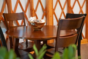 A round wooden table with a woven basket containing items.