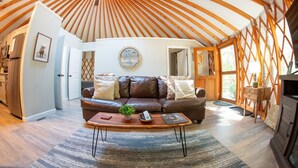 Un salon chaleureux avec un canapé en cuir, une table basse et un plafond en bois.