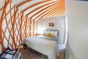 Ein Schlafzimmer mit einem Bett, einer Holzwand mit Gittermuster und einem Gemälde.
