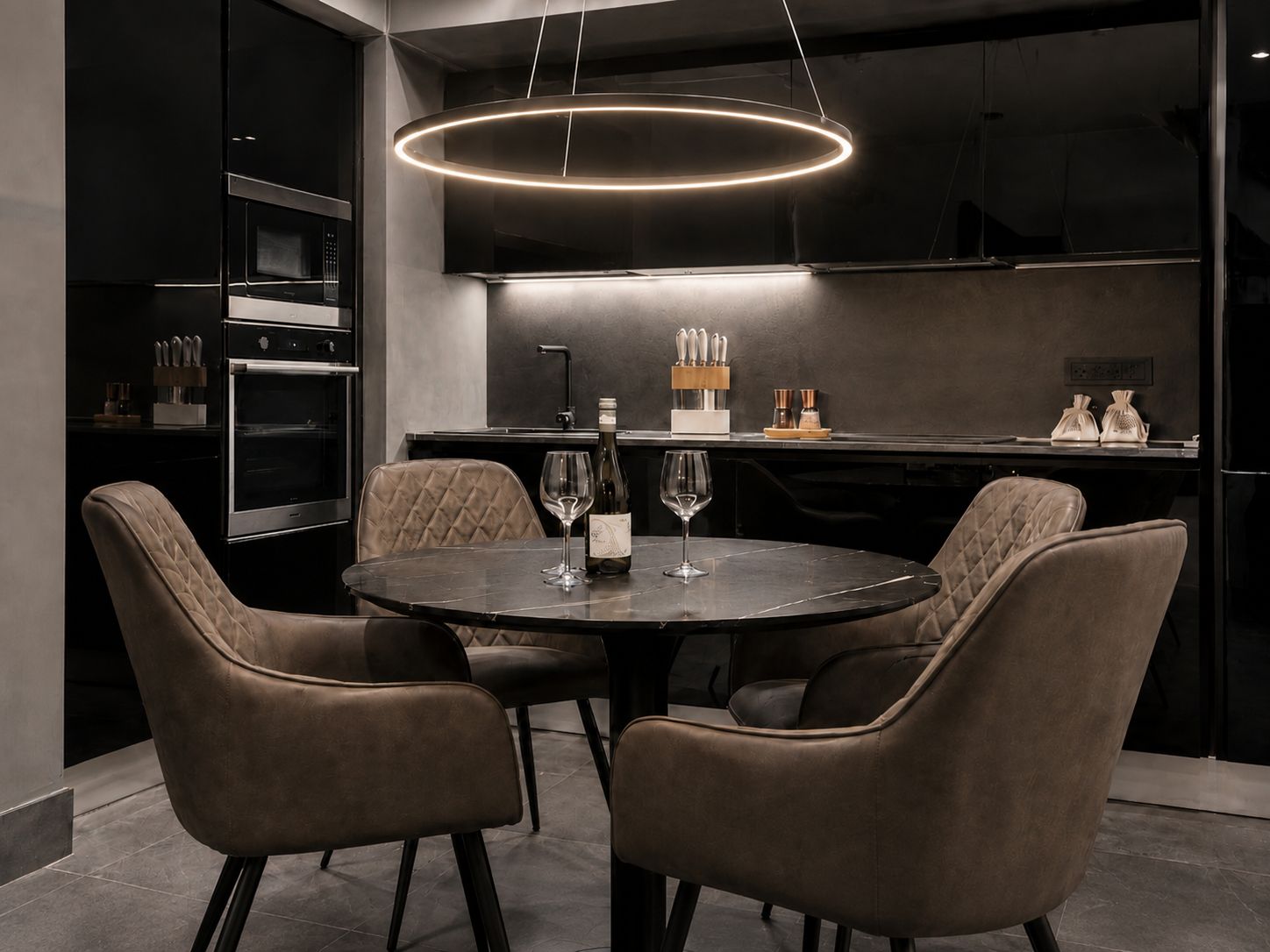 A modern kitchen with a round dining table, four chairs, and a pendant light.