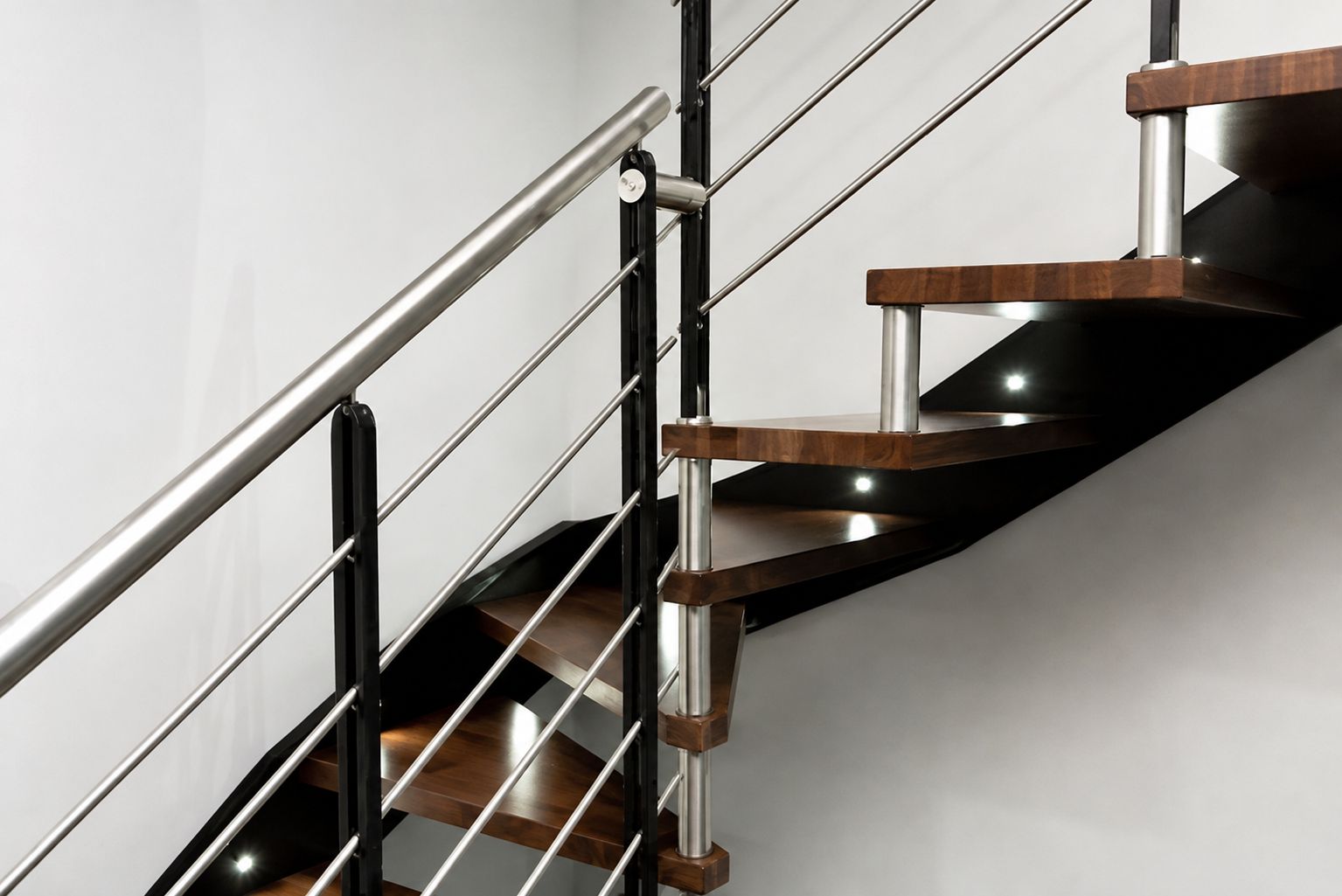 Eine moderne Treppe mit Metallgeländern und Holzstufen.