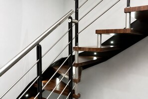 Una escalera moderna con barandillas de metal y escalones de madera.