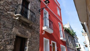 A red building with white-framed windows and a stone facade.