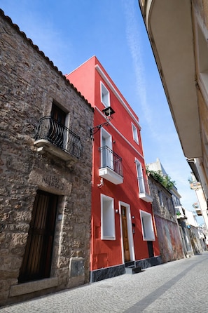 Ein rotes Gebäude mit weiß umrandeten Fenstern und einer Stein-Fassade.