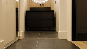 A modern bathroom with a vanity, a mirror, and a circular light fixture.