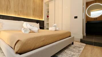Een moderne slaapkamer met een groot bed, een houten hoofdbord, een inbouwkast en een ronde spiegel boven het bed.