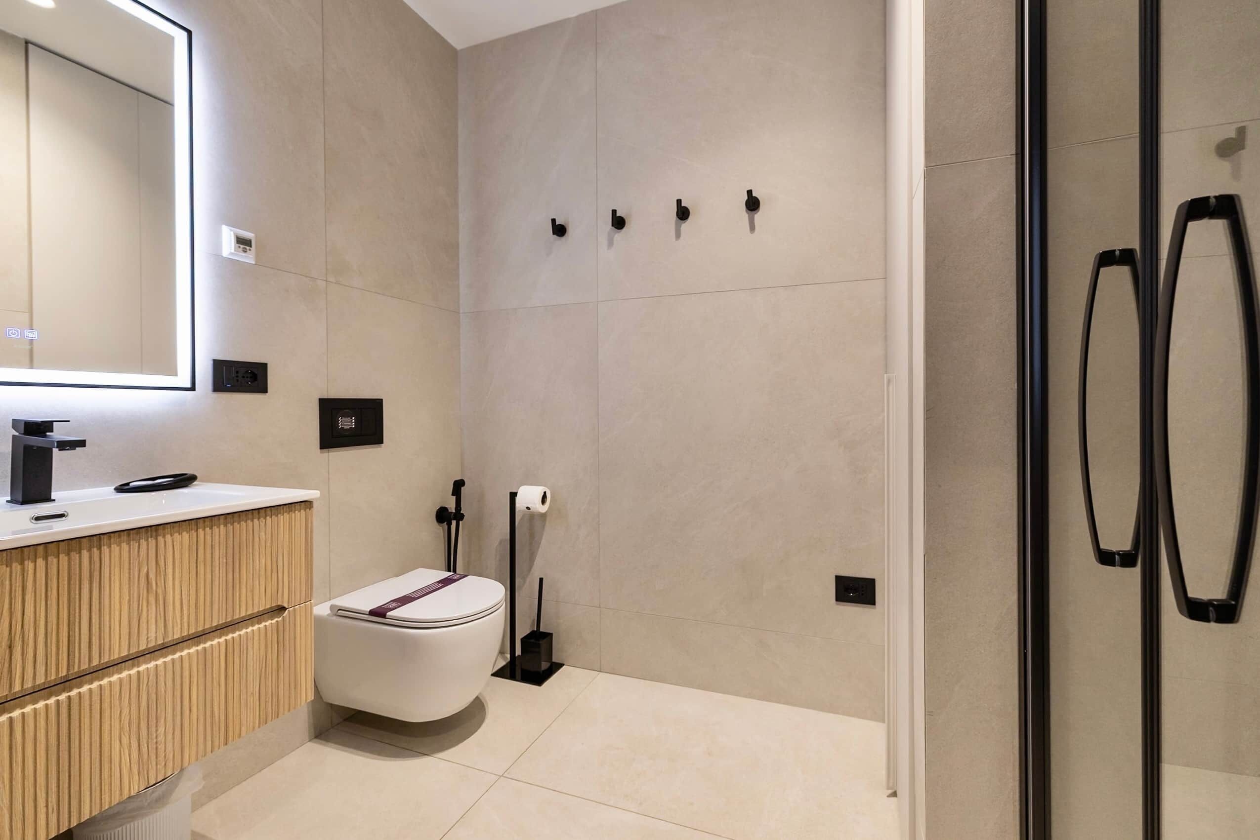 Ein modernes Badezimmer mit Toilette, Waschbecken und Duschbereich.
