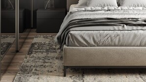 A modern bedroom with a large bed, dark walls, and a minimalist design.
