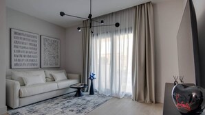 A modern living room with a sofa, a patterned rug, and a decorative lamp. - AZULIS Apartment 7 · 2BR with Terraces & Elevator in Aldo Moro (Olbia)